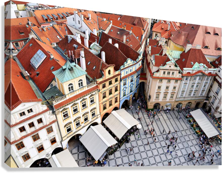 Aerial view of a bustling European city square with red roofs.