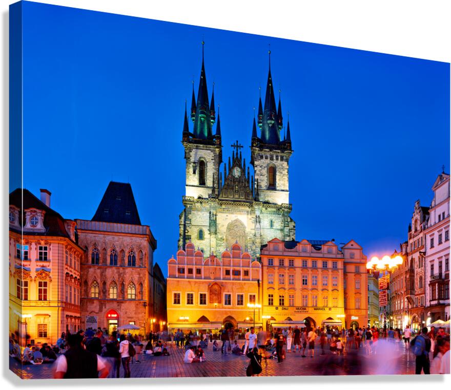 Pragues Old Town Square at night illuminated church and crowd.