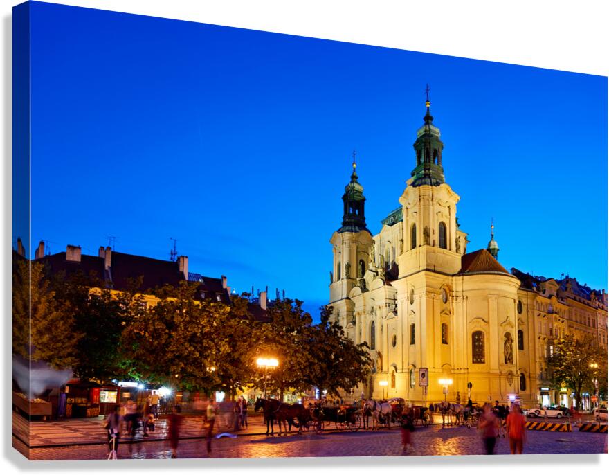 Illuminated church and lively square at night.