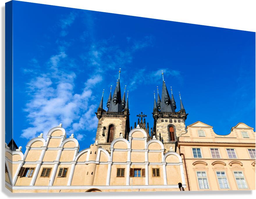 Týn Church spires and historic Prague buildings against blue sk