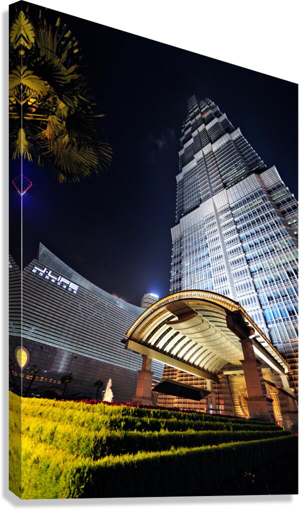 Modern skyscraper with bright entrance at night in Shanghai