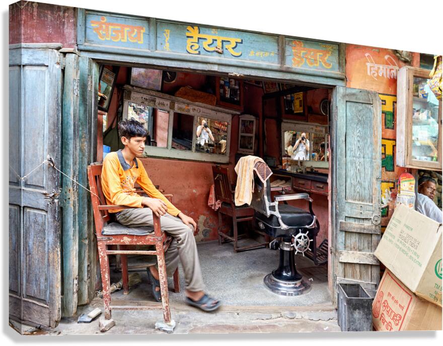 Barber shop scene in Bikaner Rajasthan showing young customer w