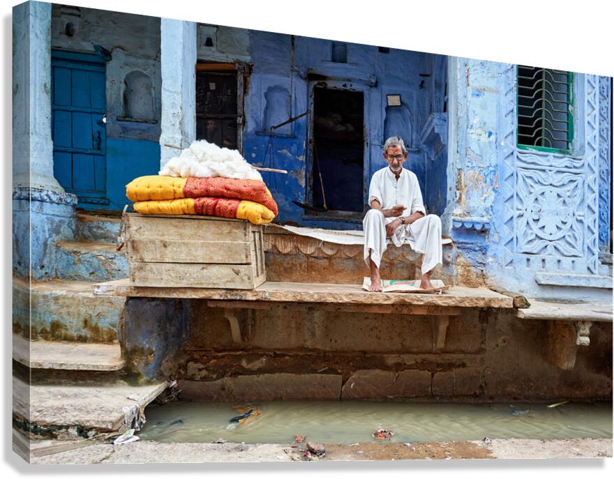 Portrait of an old man sitting by a blue building in Bundi Raja