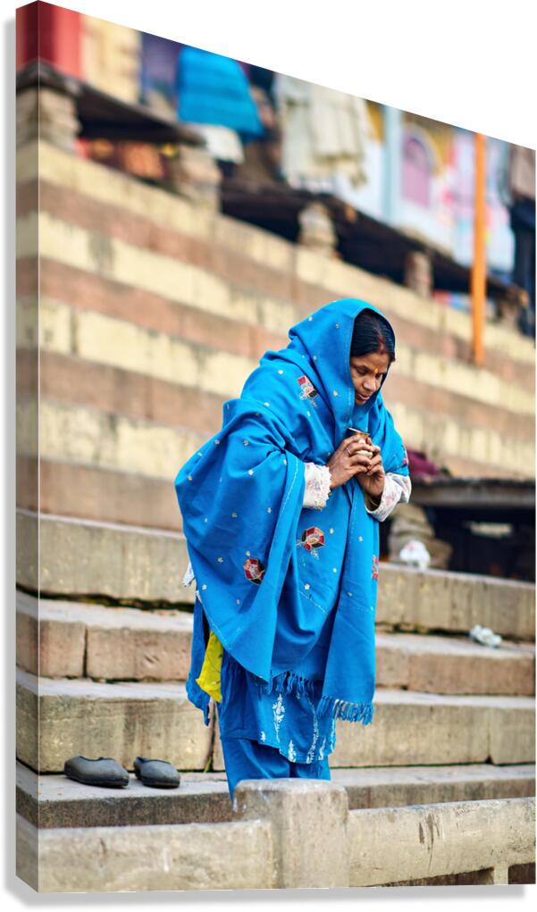 Woman praying by the Ganges in Varanasi during morning hours