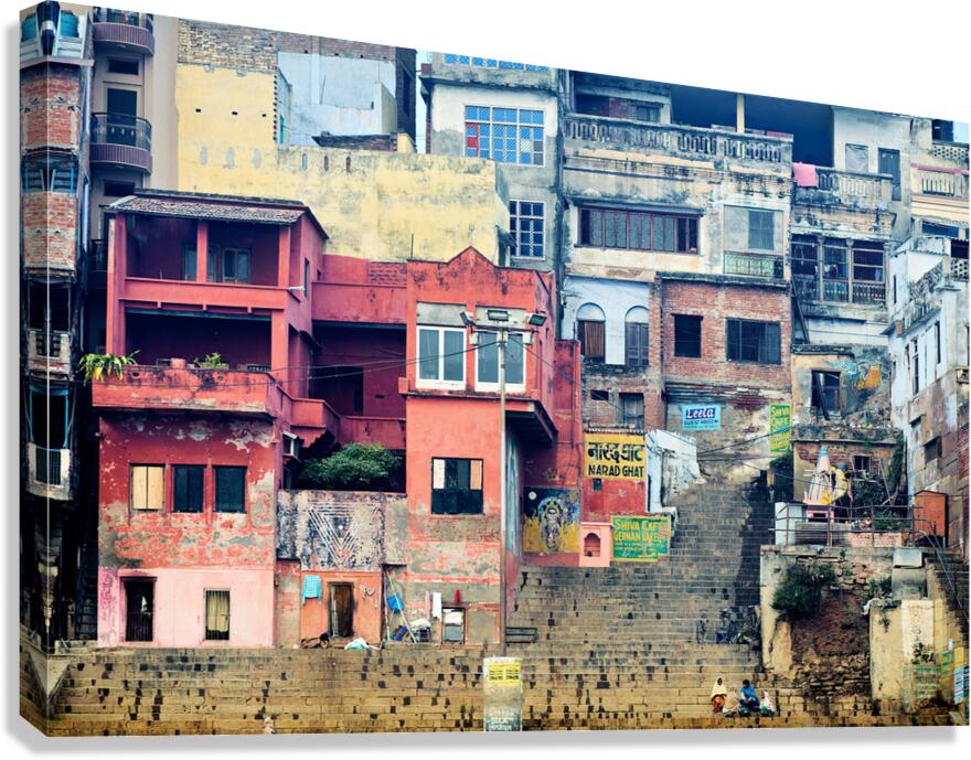 Visitors walk along the ghat by the Ganges river in Varanasi In