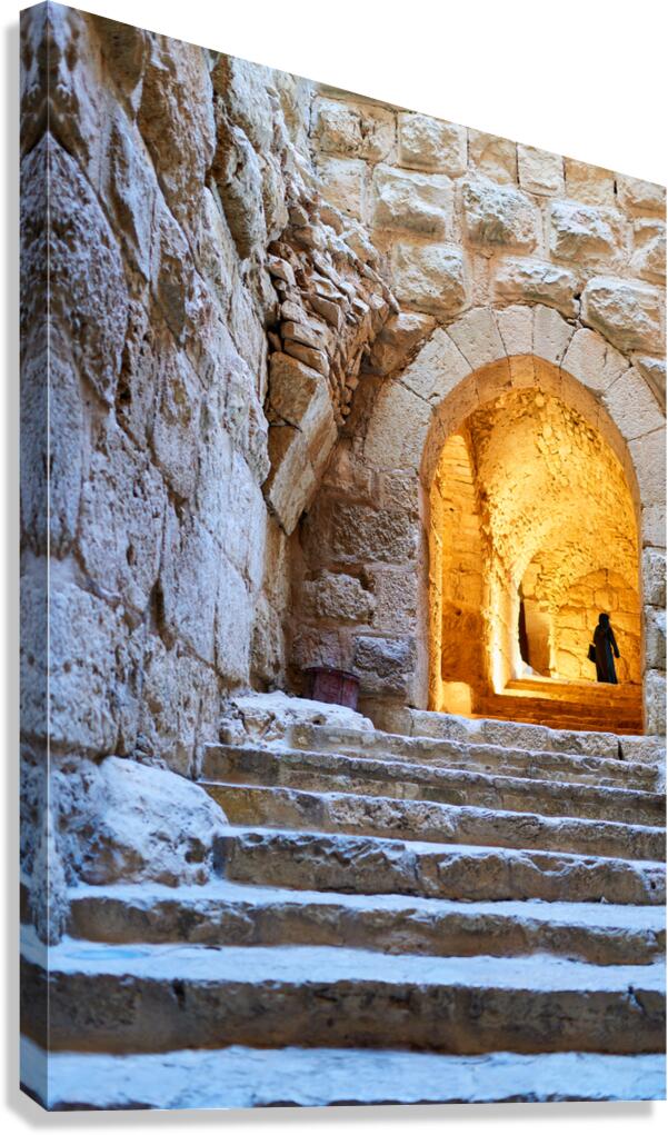 A person walks up stone stairs inside Ajloun castle in Jordan