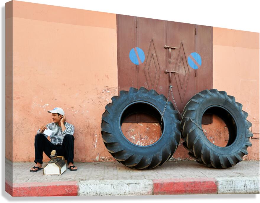 Shoe shine service in Marrakesh old town near large tires