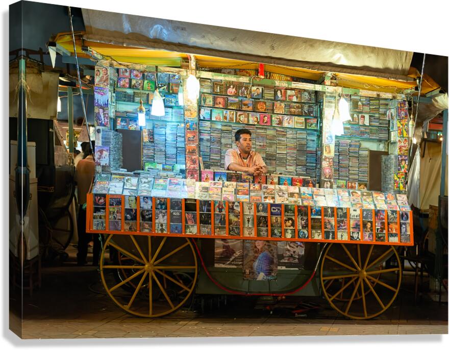 CD stall in Marrakesh at night with vendor selling music