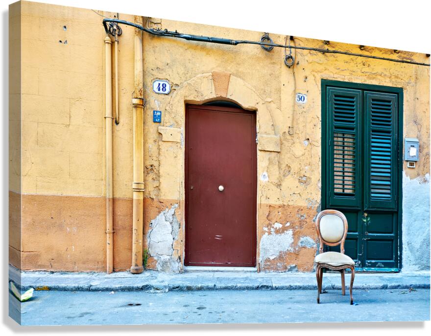 Empty chair in front of colorful building in Palermo Sicily Ital