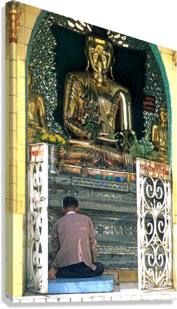 Man prays before a golden Buddha statue in Myanmar chapel