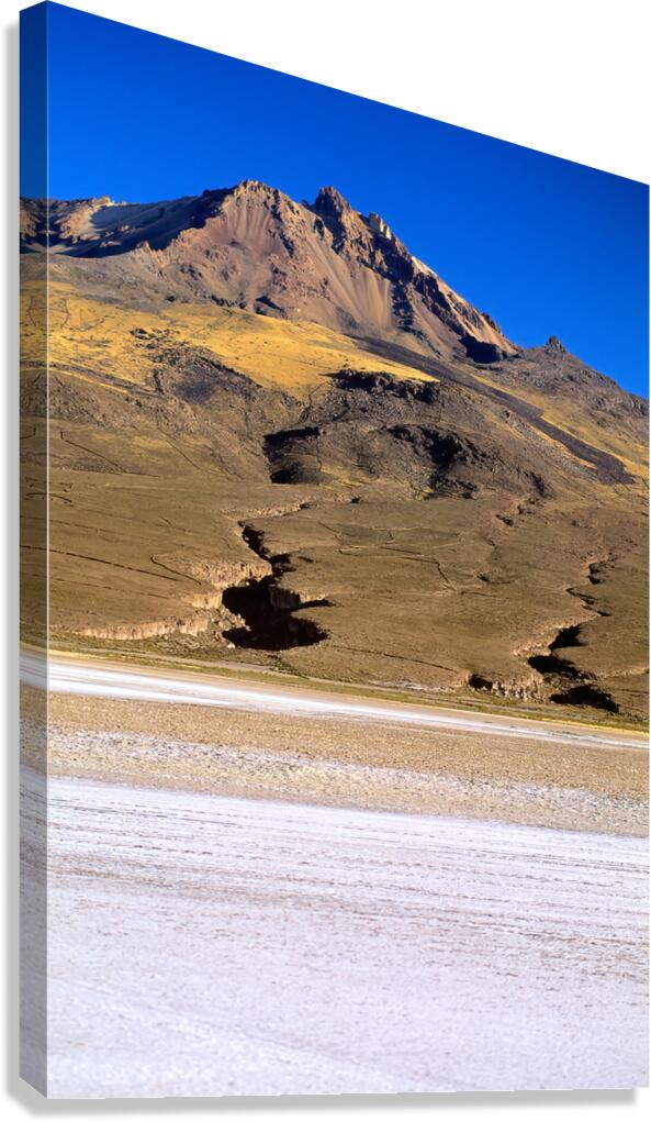 Mountain overlooks vast salt flat under clear blue sky.