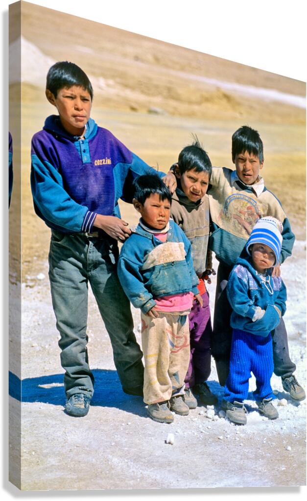 Five young boys pose together on a dirt road.