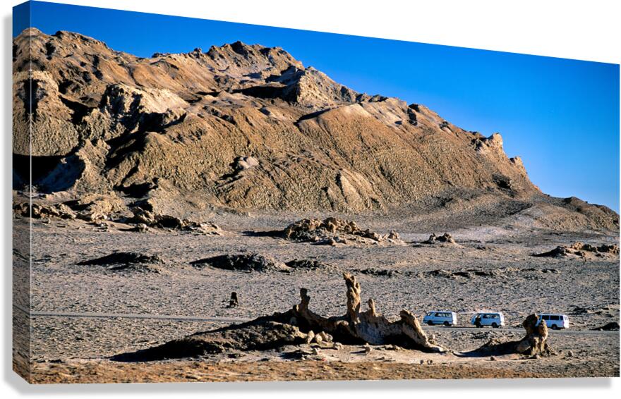 Arid mountain landscape with vans on a desert road.