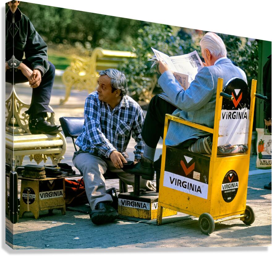 Shoeshine man works while customer reads newspaper.