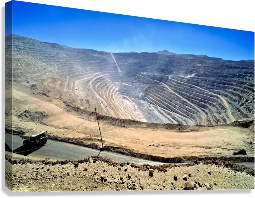 Vast open pit mine with terraced walls and haul truck.