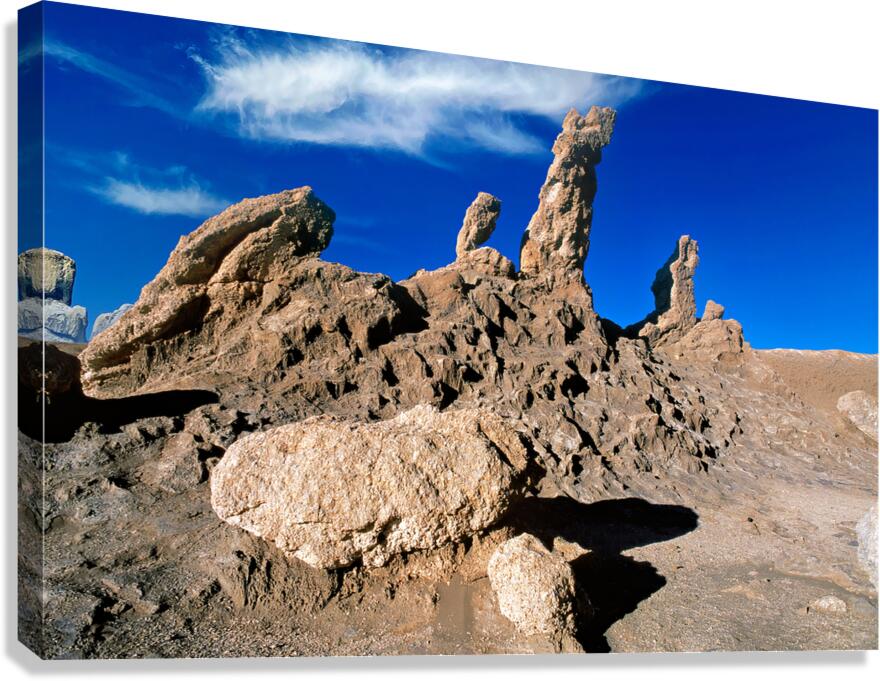 Dramatic desert rock formations under a vibrant blue sky.