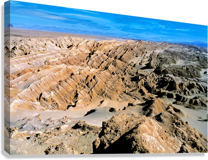Dramatic desert landscape with eroded formations under a blue sk