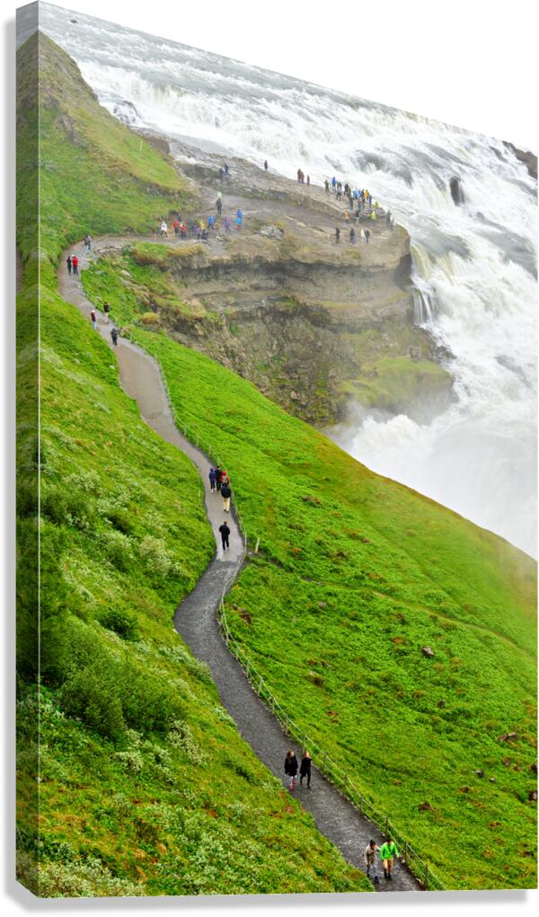 Visitors explore Gullfoss waterfall in Iceland on a cloudy day