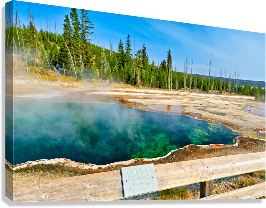 Tourists can see the deep blue Abyss Pool in Yellowstone National Park with steam rising from the hot springs during the warm afternoon.