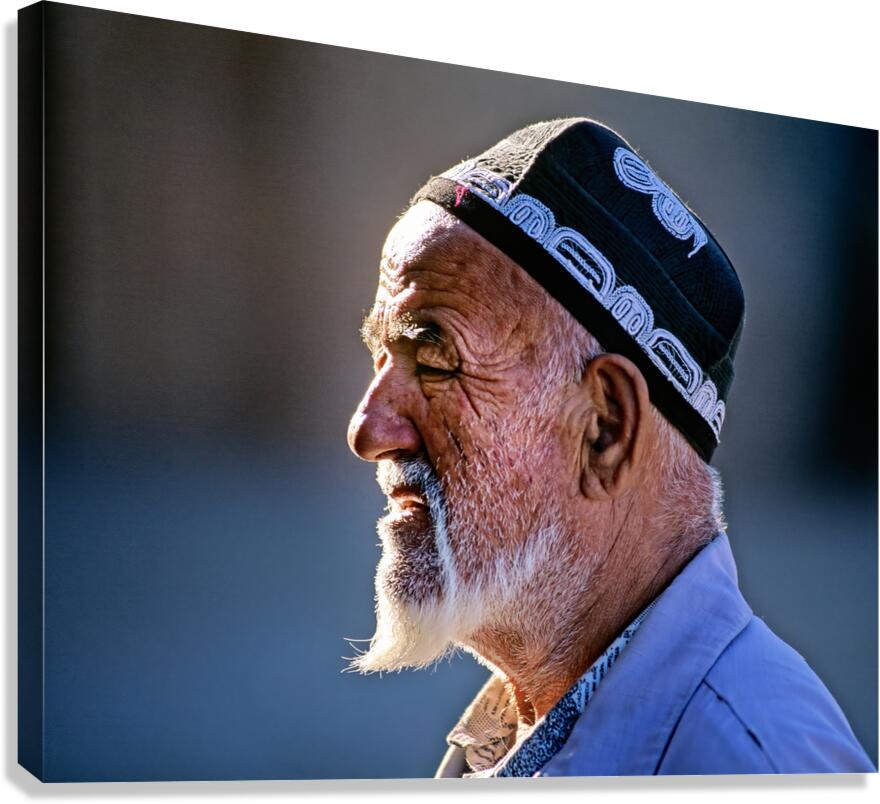 Elderly man in traditional clothing walks in Khiva Uzbekistan