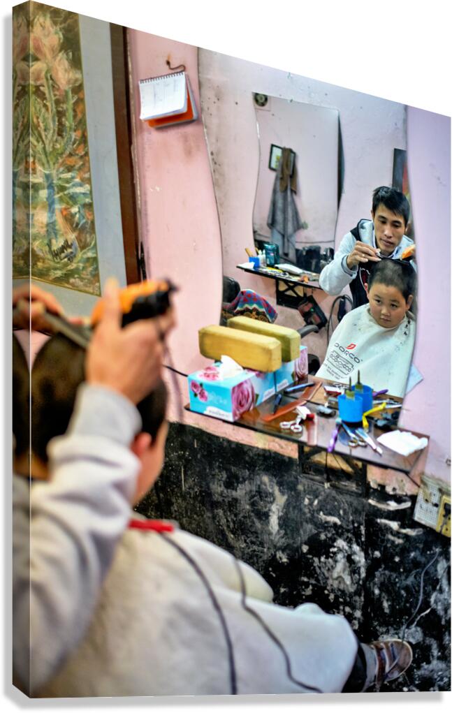 Young boy gets a haircut in a Hanoi barbershop
