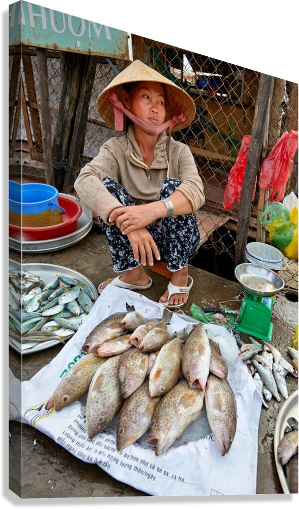 Fish seller sits by market stall in Phu Quoc Vietnam