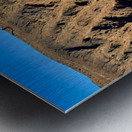 Hiker traverses a dramatic shadowed desert landscape. Metal print