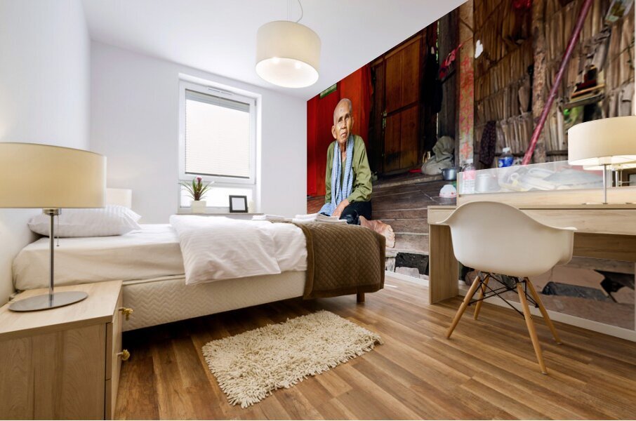 Elderly person sitting on floor in rustic dwelling. Mural print