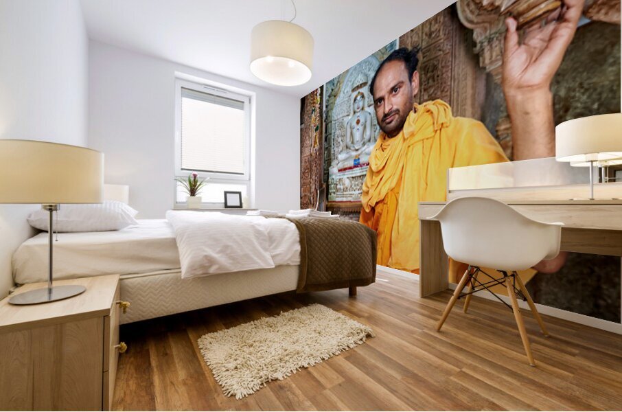 Hindu monk stands near statue in Jaisalmer Jain temple Mural print