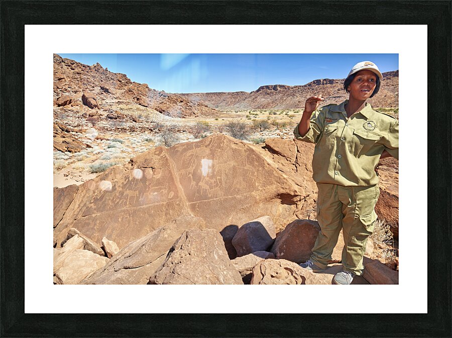 Namibia. A guide shows prehistoric rock engravings in Twyfelfontein archaeological site Picture Frame print