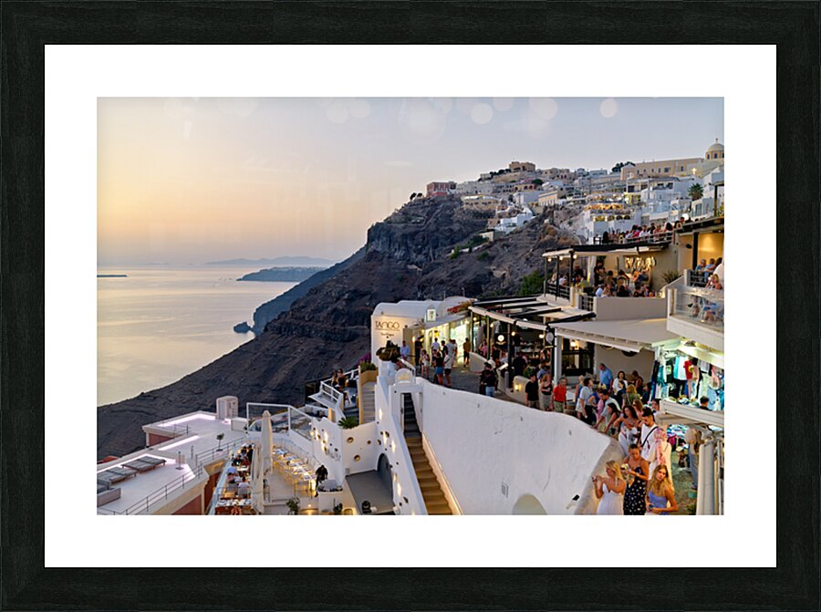 Santorini cliffside town with restaurants and people enjoying th Picture Frame print
