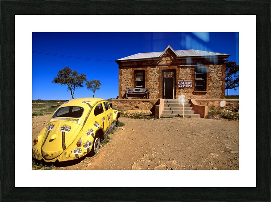 A painted yellow Beetle outside a rural stone gallery. Picture Frame print