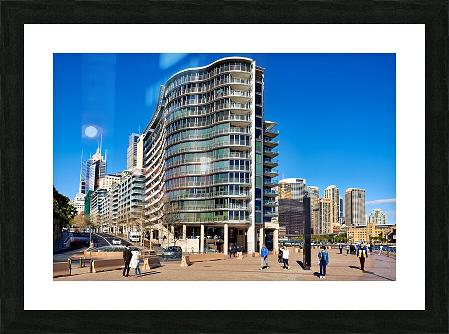 Modern curved building with balconies and city skyline. Picture Frame print
