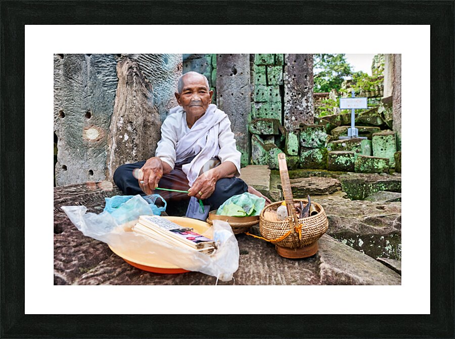 Elderly person selling goods at ancient temple ruins. Picture Frame print