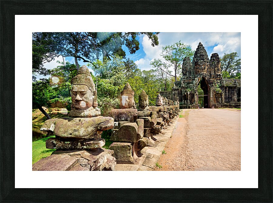 Ancient stone statues line path to Angkor Thom gate. Picture Frame print