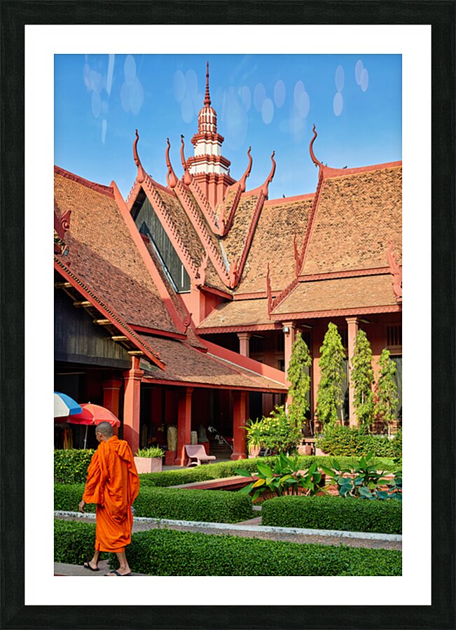Monk walks through traditional Cambodian temple garden. Picture Frame print