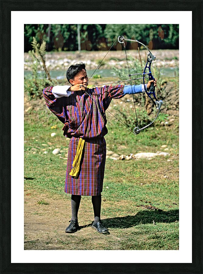 Bhutanese archer in traditional Gho aiming a compound bow. Picture Frame print