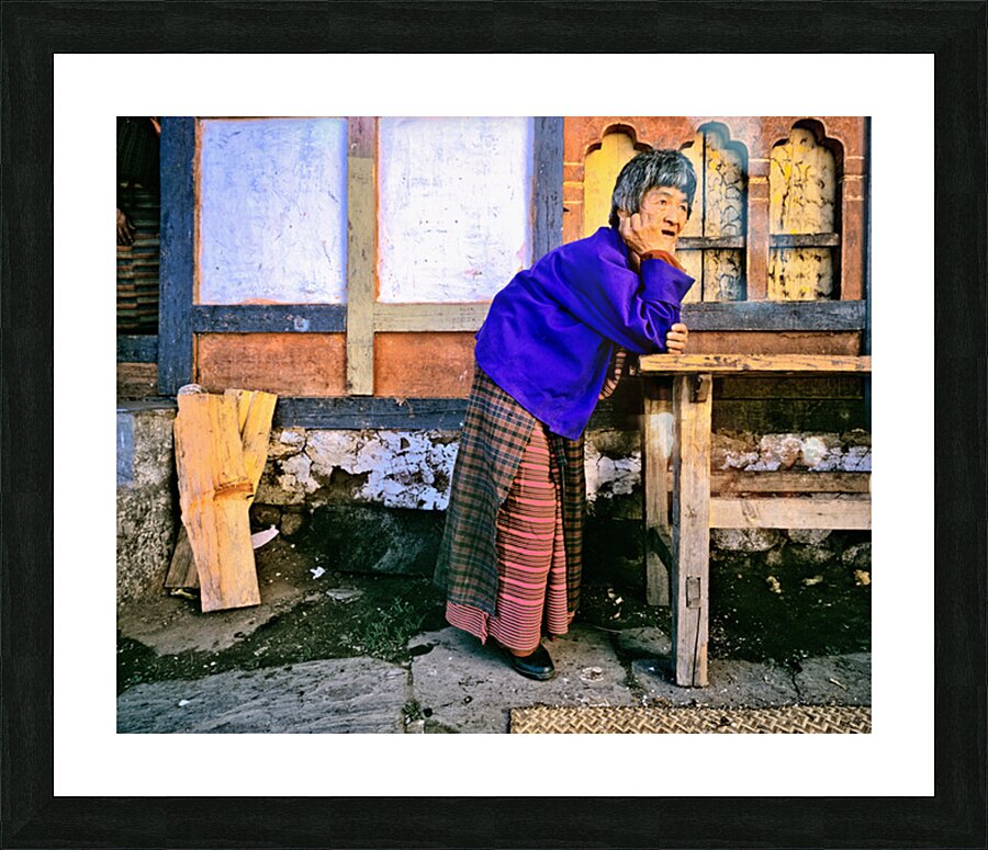 Smiling elderly woman in traditional dress leaning on wooden tab Picture Frame print