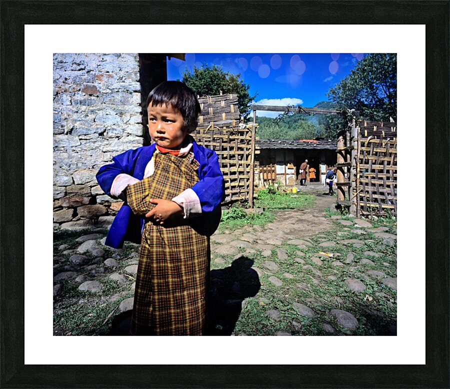 Young child in traditional Bhutanese dress in village. Picture Frame print