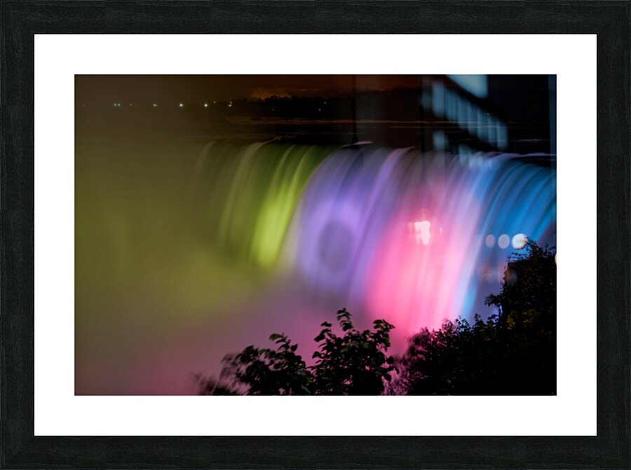 Niagara Falls illuminated with vibrant colors at night. Picture Frame print