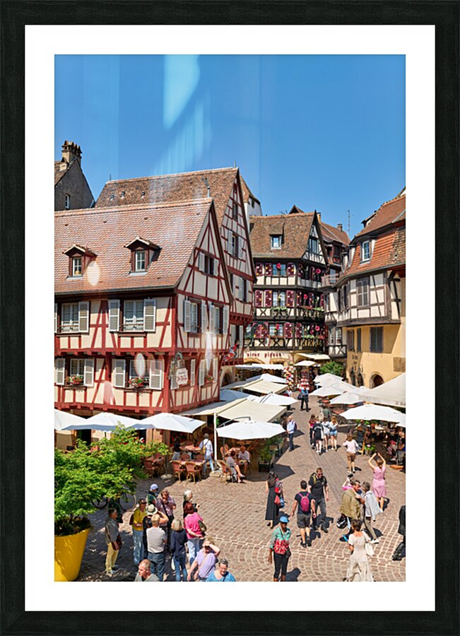 Visitors walk through Colmar on sunny day near timber framed hou Picture Frame print