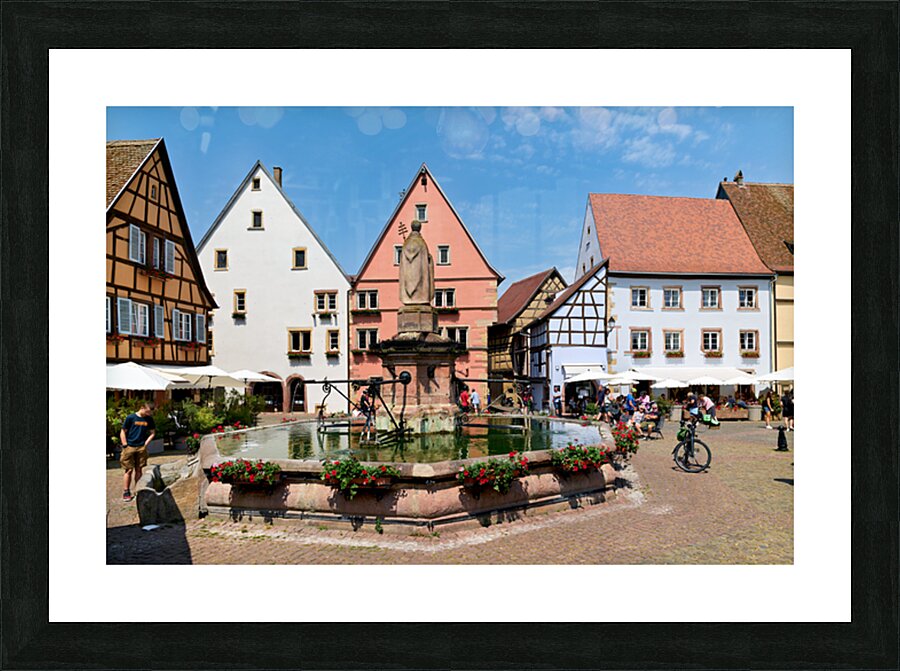 Visitors enjoy Saint Leon square in Eguisheim Alsace on a sunny Picture Frame print