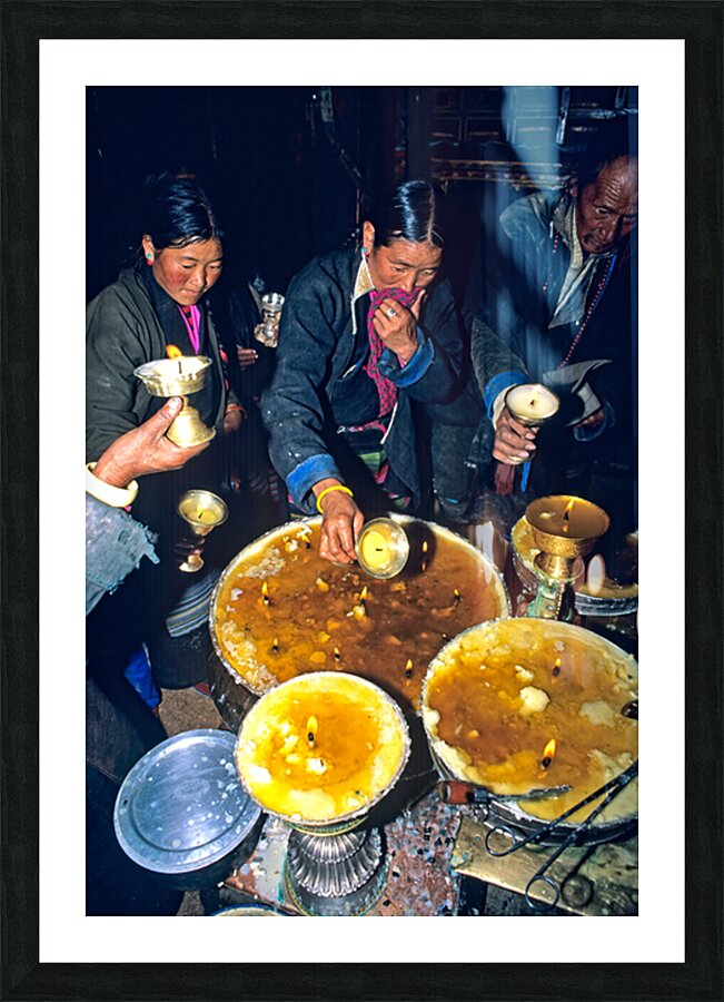 Lighting butter lamps during a ceremony in Tibet Picture Frame print