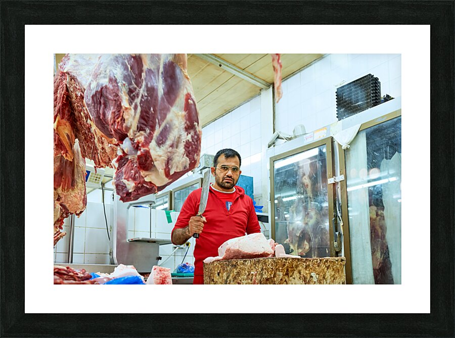 Butcher works with meat in a shop in Dubai UAE Picture Frame print