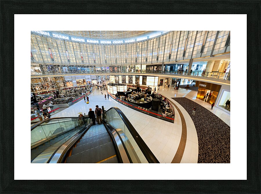 Busy shopping mall in Dubai with escalators and various stores Picture Frame print