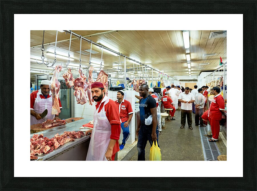 Butchers work at a busy meat market in Dubai UAE preparing fresh Picture Frame print
