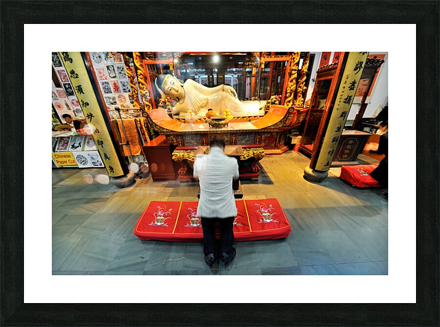 Worshipper kneels before Buddha statue in Shanghai temple Picture Frame print