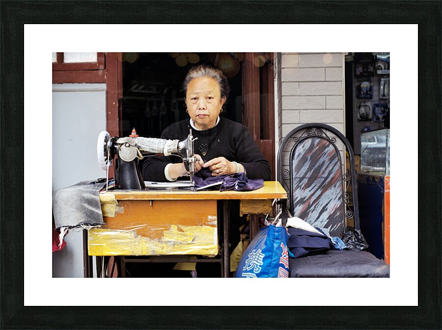 Elderly woman sews at machine in Shanghai China Picture Frame print