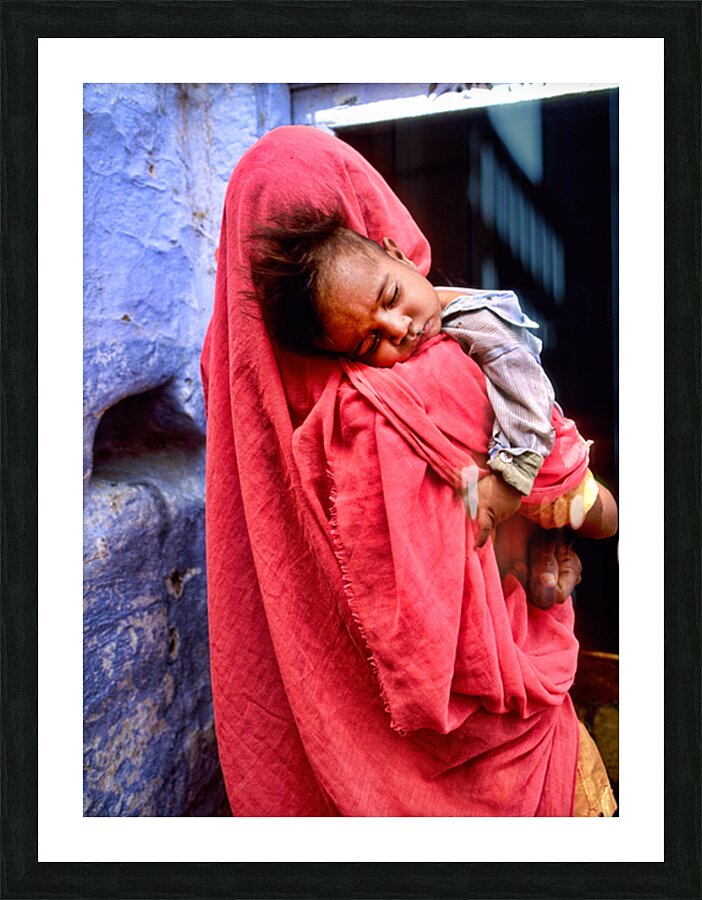Mother carries sleeping child in India during daytime Picture Frame print