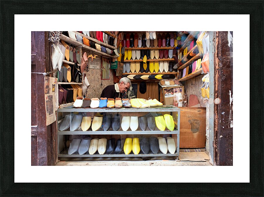 Moroccan babouches shoes in a Fez shop with a vendor Picture Frame print